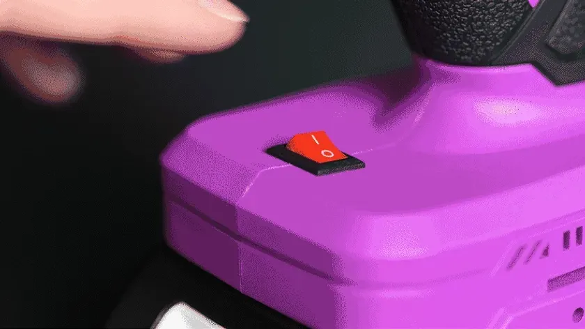 紫色のデバイスの電源スイッチを指で押している様子。